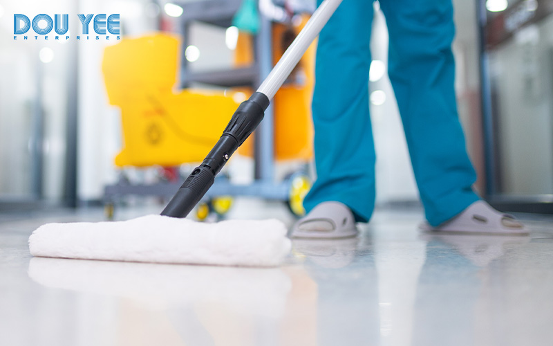 A person mopping a sterile floor with a mop and bucket.